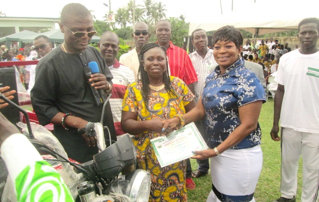 Mrs Queenstar Maame Pokuah Sawyerr (right) presenting a certificate to the Overall Best Teacher, Ms Hilda Mensah. With them on is Mr Kofi Adams (with mic)